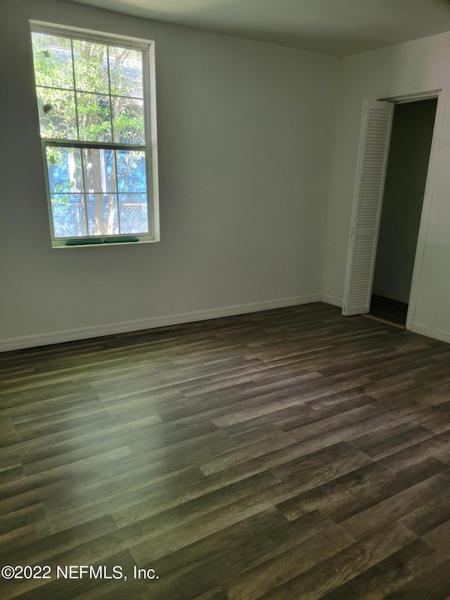 unfurnished room with dark hardwood / wood-style flooring