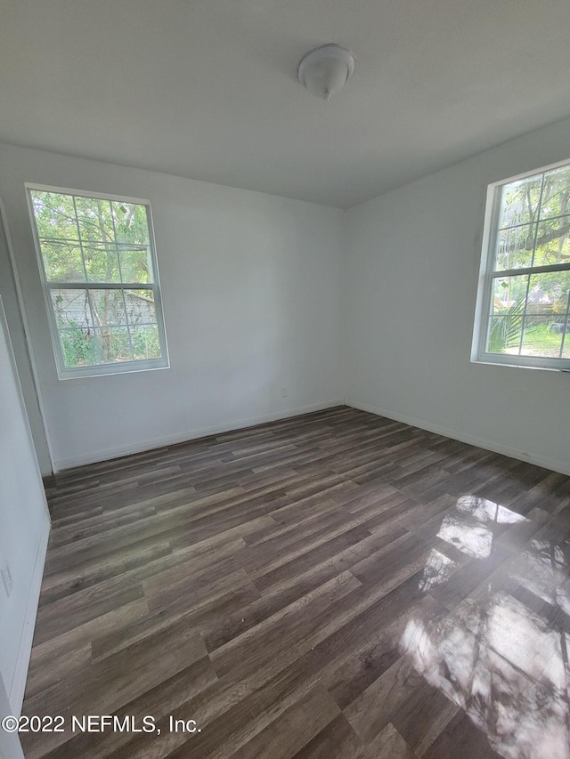 unfurnished room with dark hardwood / wood-style flooring