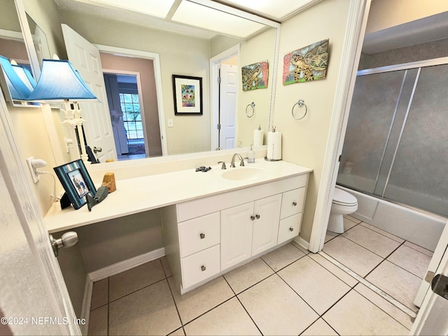 full bathroom with toilet, vanity, tile patterned floors, and enclosed tub / shower combo