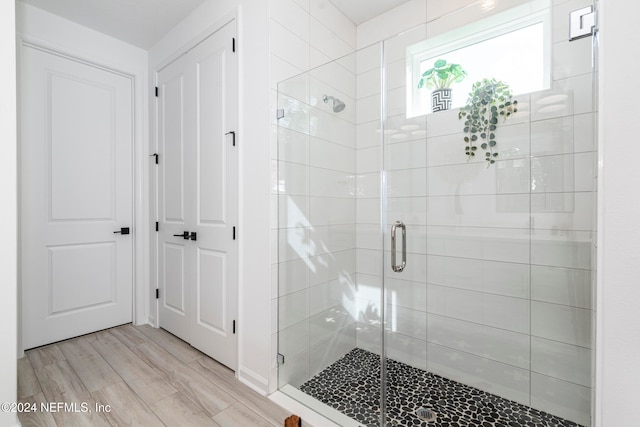 bathroom featuring hardwood / wood-style flooring and an enclosed shower