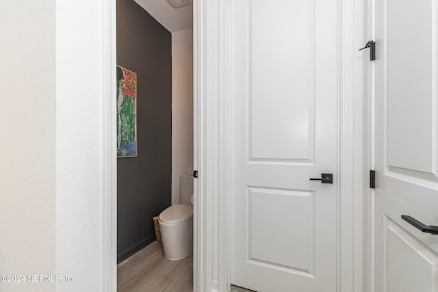 bathroom with hardwood / wood-style floors and toilet