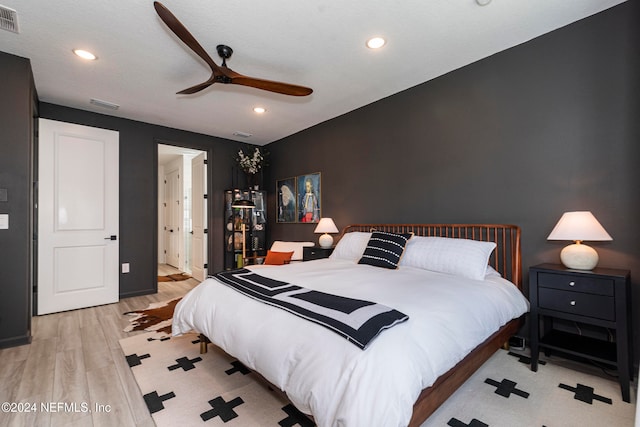 bedroom featuring ceiling fan, light wood-type flooring, and a textured ceiling