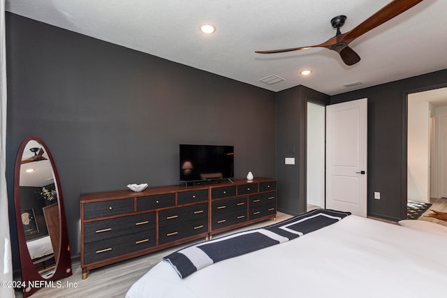 bedroom featuring a textured ceiling, light hardwood / wood-style floors, and ceiling fan