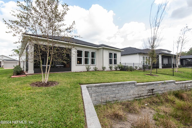 rear view of house featuring a lawn