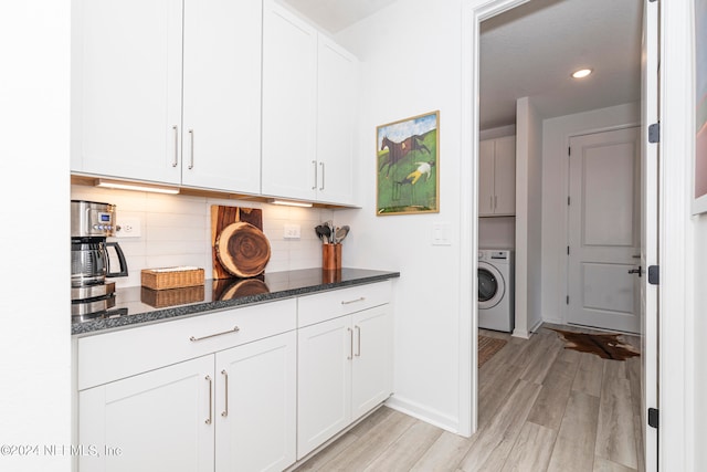 laundry area with cabinets, washer / clothes dryer, and light hardwood / wood-style flooring