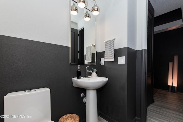 bathroom featuring wood-type flooring and toilet