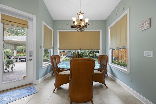 tiled dining space featuring plenty of natural light and a chandelier