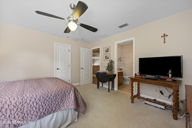 bedroom featuring light carpet, a textured ceiling, connected bathroom, and ceiling fan