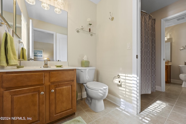 bathroom featuring tile patterned flooring, vanity, and toilet