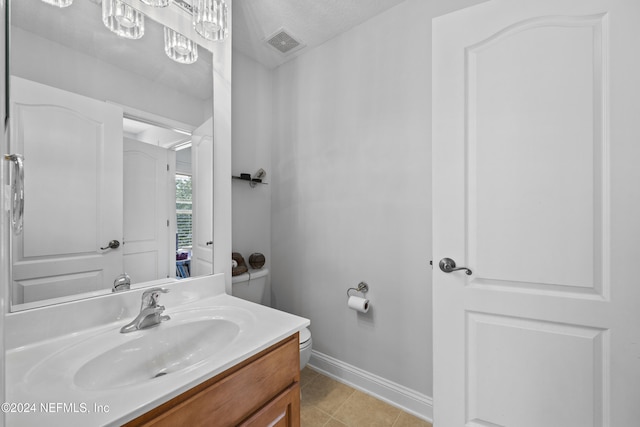 bathroom featuring tile patterned flooring, vanity, and a chandelier