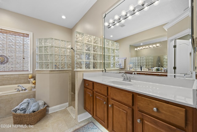 bathroom featuring plus walk in shower, vanity, and tile patterned floors