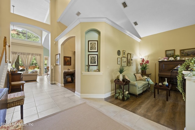 interior space with light tile patterned floors and high vaulted ceiling