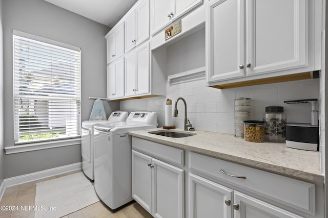 laundry room with plenty of natural light, cabinets, separate washer and dryer, and sink