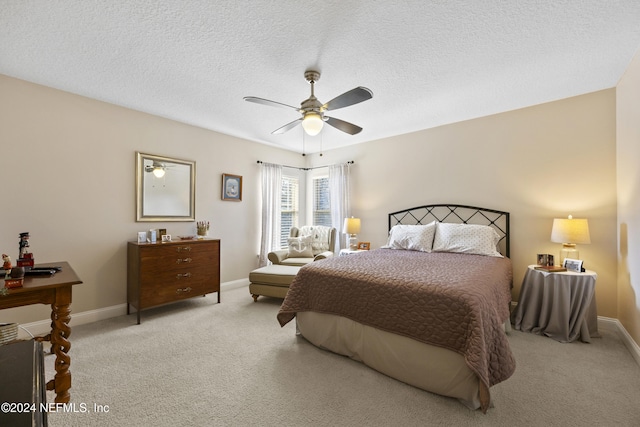 carpeted bedroom featuring a textured ceiling and ceiling fan