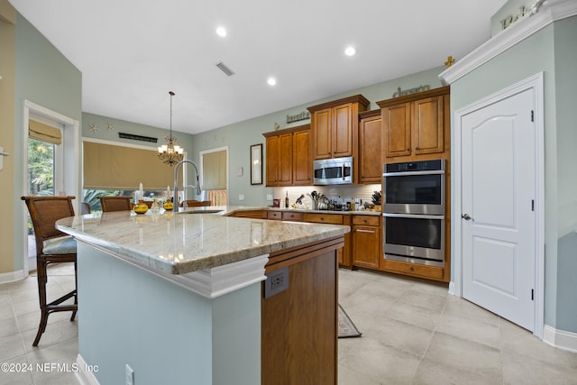 kitchen with a breakfast bar, stainless steel appliances, a center island with sink, and sink