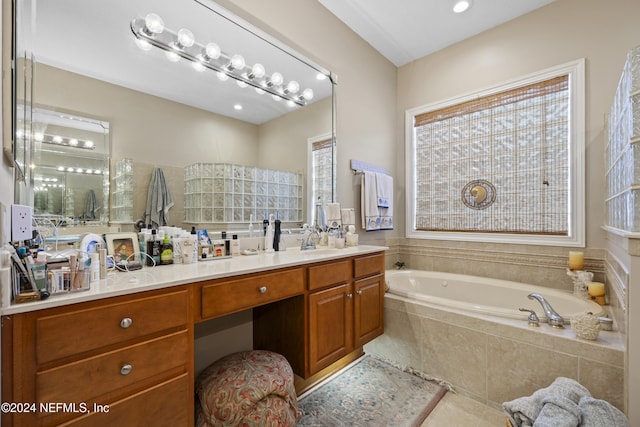 bathroom with vanity and tiled tub