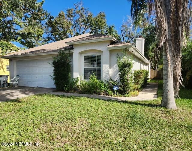 ranch-style home with a garage and a front lawn