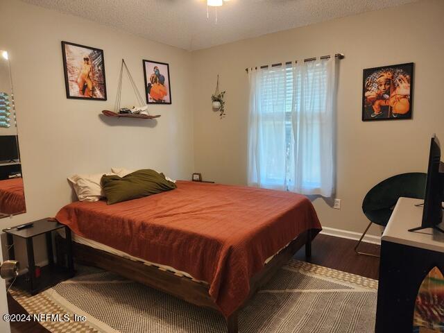 bedroom featuring a textured ceiling and hardwood / wood-style flooring