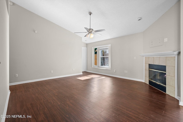 unfurnished living room with ceiling fan, dark hardwood / wood-style flooring, a fireplace, and vaulted ceiling