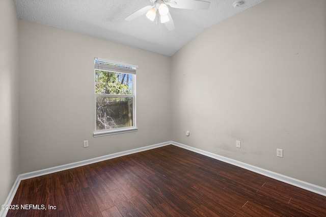 empty room featuring dark wood-type flooring, a ceiling fan, baseboards, and a textured ceiling