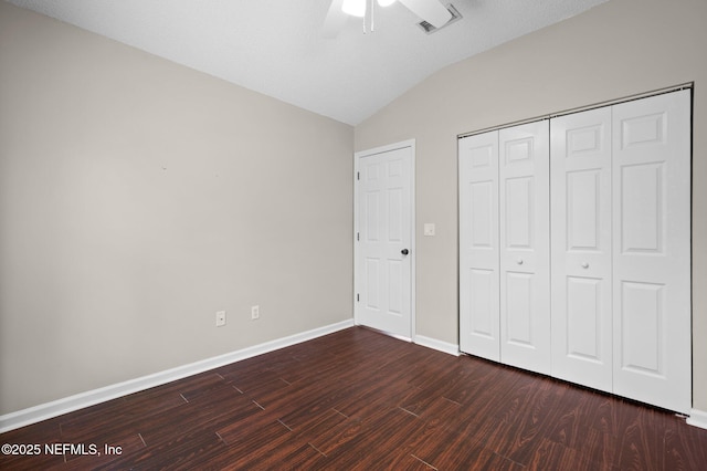 unfurnished bedroom with ceiling fan, baseboards, vaulted ceiling, wood finished floors, and a closet