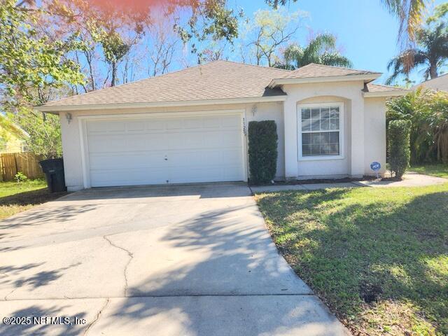 ranch-style house featuring fence, driveway, an attached garage, stucco siding, and a front lawn