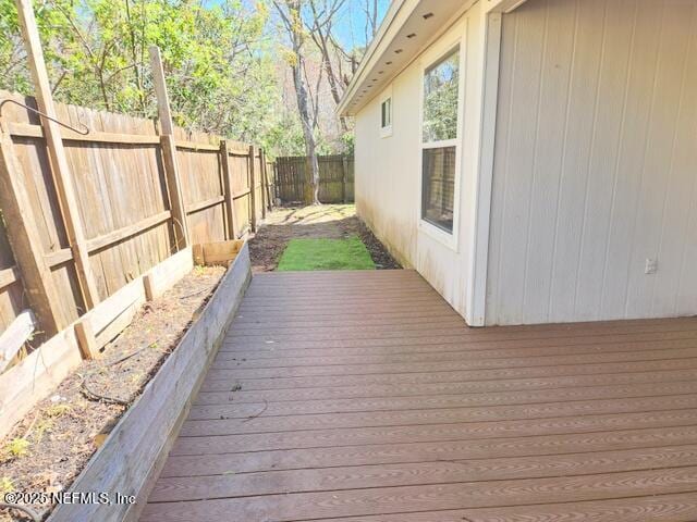 wooden deck with a fenced backyard