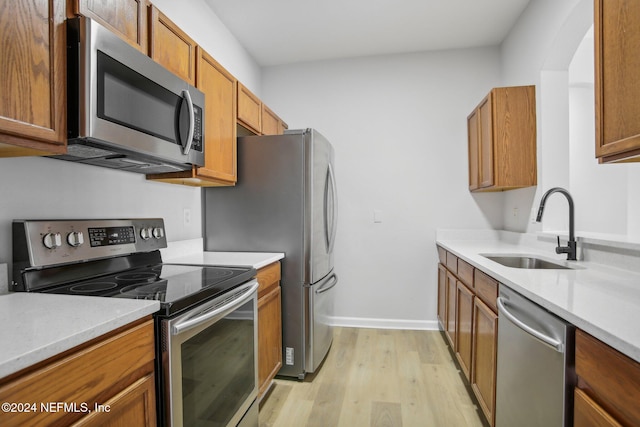 kitchen with sink, light hardwood / wood-style floors, and appliances with stainless steel finishes