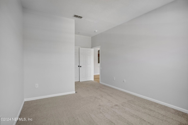 unfurnished room featuring light carpet