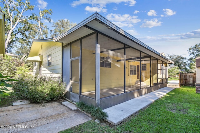 rear view of property featuring a sunroom