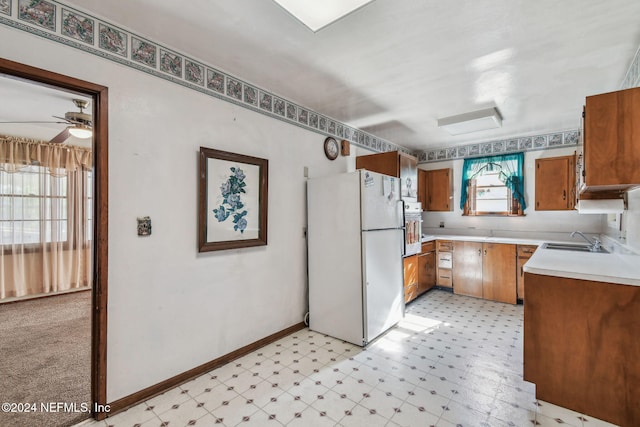 kitchen featuring ceiling fan, white fridge, and sink