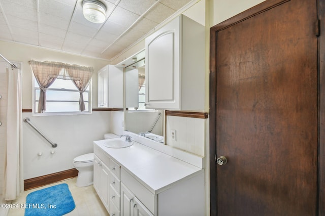 bathroom with a paneled ceiling, vanity, and toilet