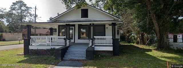 bungalow with a porch and a front lawn