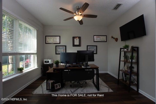 office with a wealth of natural light, a textured ceiling, ceiling fan, and dark wood-type flooring