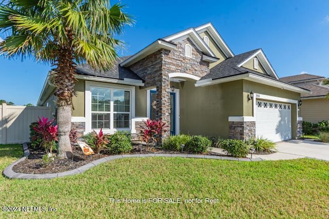 craftsman-style house featuring a front yard and a garage