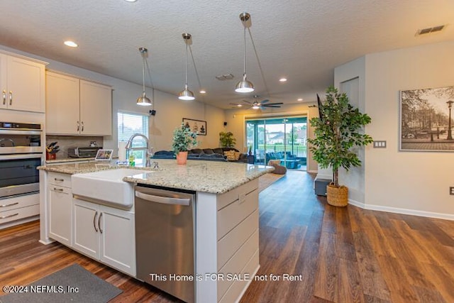 kitchen featuring white cabinetry, ceiling fan, sink, a kitchen island with sink, and appliances with stainless steel finishes