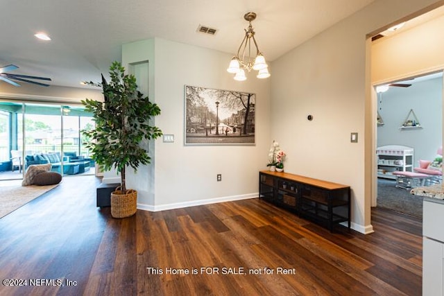 corridor featuring dark hardwood / wood-style flooring and a chandelier