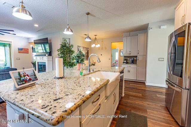 kitchen featuring pendant lighting, a spacious island, light stone countertops, and stainless steel appliances