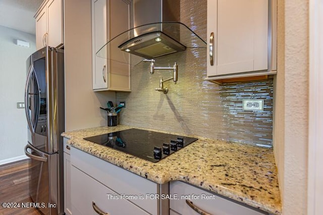 kitchen featuring ventilation hood, white cabinets, decorative backsplash, light stone counters, and stainless steel appliances