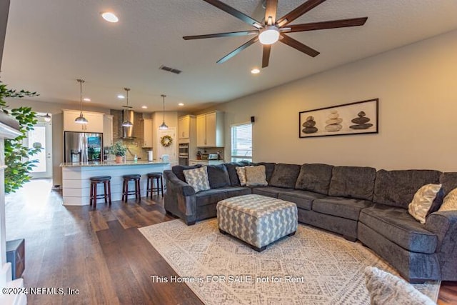 living room with ceiling fan and dark hardwood / wood-style flooring