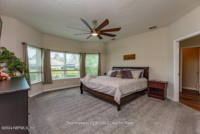 carpeted bedroom featuring a textured ceiling and ceiling fan