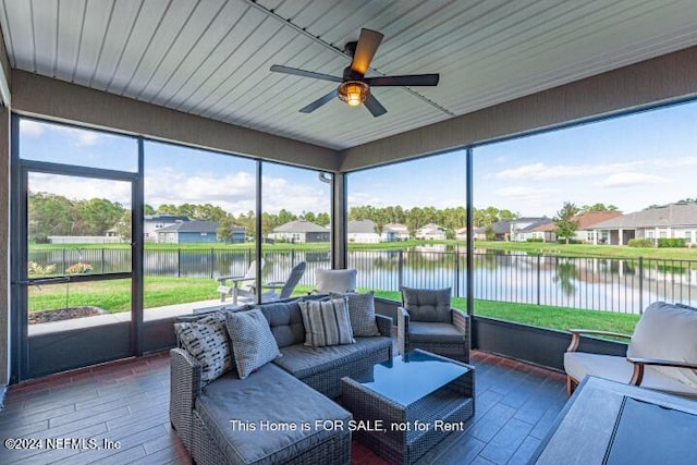 sunroom with ceiling fan, plenty of natural light, and a water view