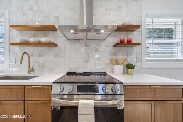 kitchen featuring light stone countertops, backsplash, ventilation hood, sink, and electric stove