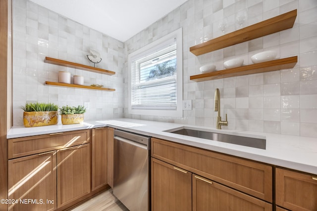 kitchen featuring dishwasher, backsplash, sink, light hardwood / wood-style flooring, and tile walls