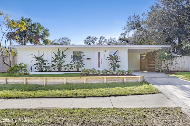 view of front of home with a carport and a front lawn