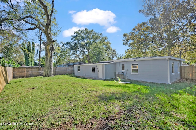 rear view of house featuring a lawn