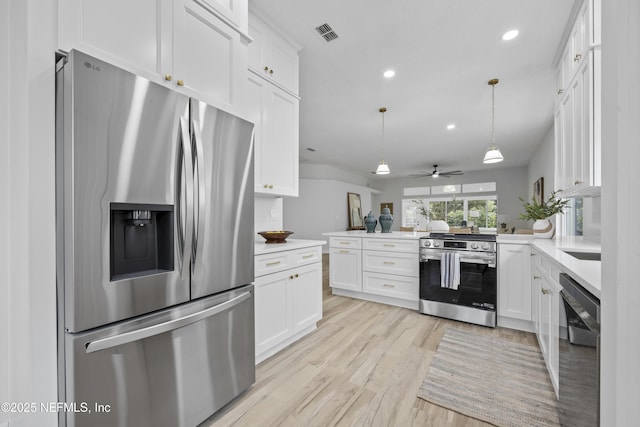 kitchen featuring kitchen peninsula, ceiling fan, decorative light fixtures, white cabinetry, and stainless steel appliances