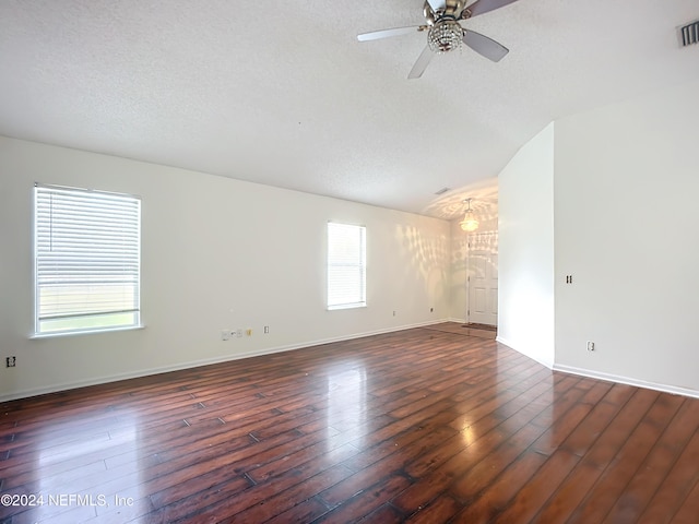 empty room featuring ceiling fan, lofted ceiling, dark wood-type flooring, and a textured ceiling