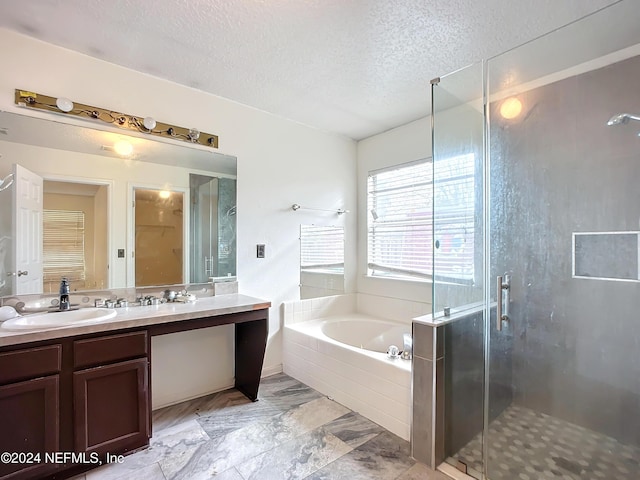 bathroom featuring vanity, shower with separate bathtub, and a textured ceiling