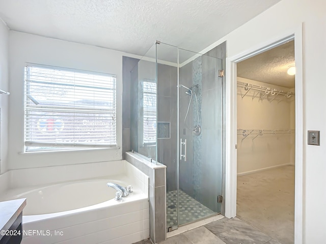 bathroom featuring vanity, a textured ceiling, and separate shower and tub